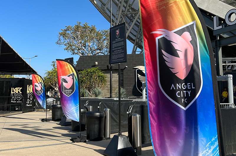 Pride flags with the Angel city logo line the entrance on Pride Night at the Banc of California.