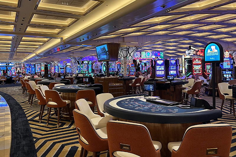 Casino at resorts world, tables in front, slot machines in back